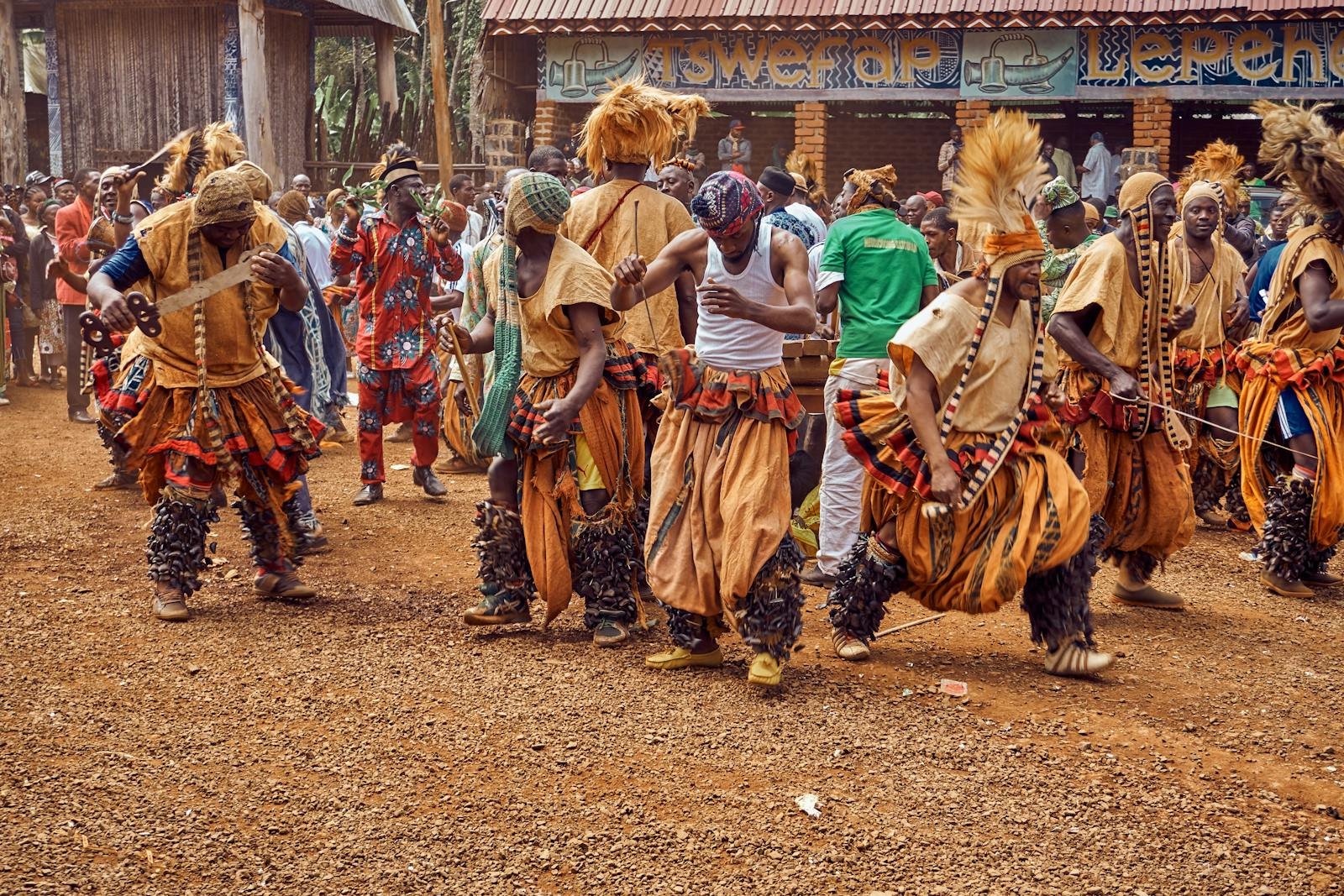 People in Traditional Dress Dancing on Brown Field