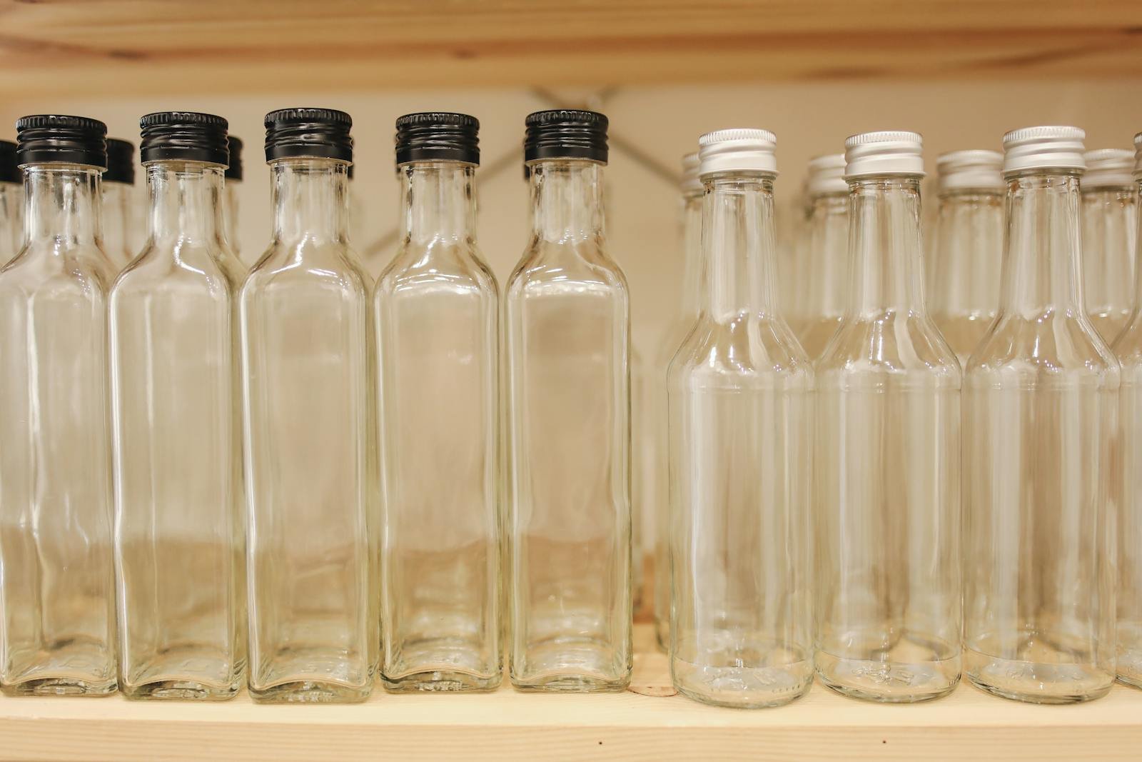 Clear Glass Bottles On Brown Wooden Shelf