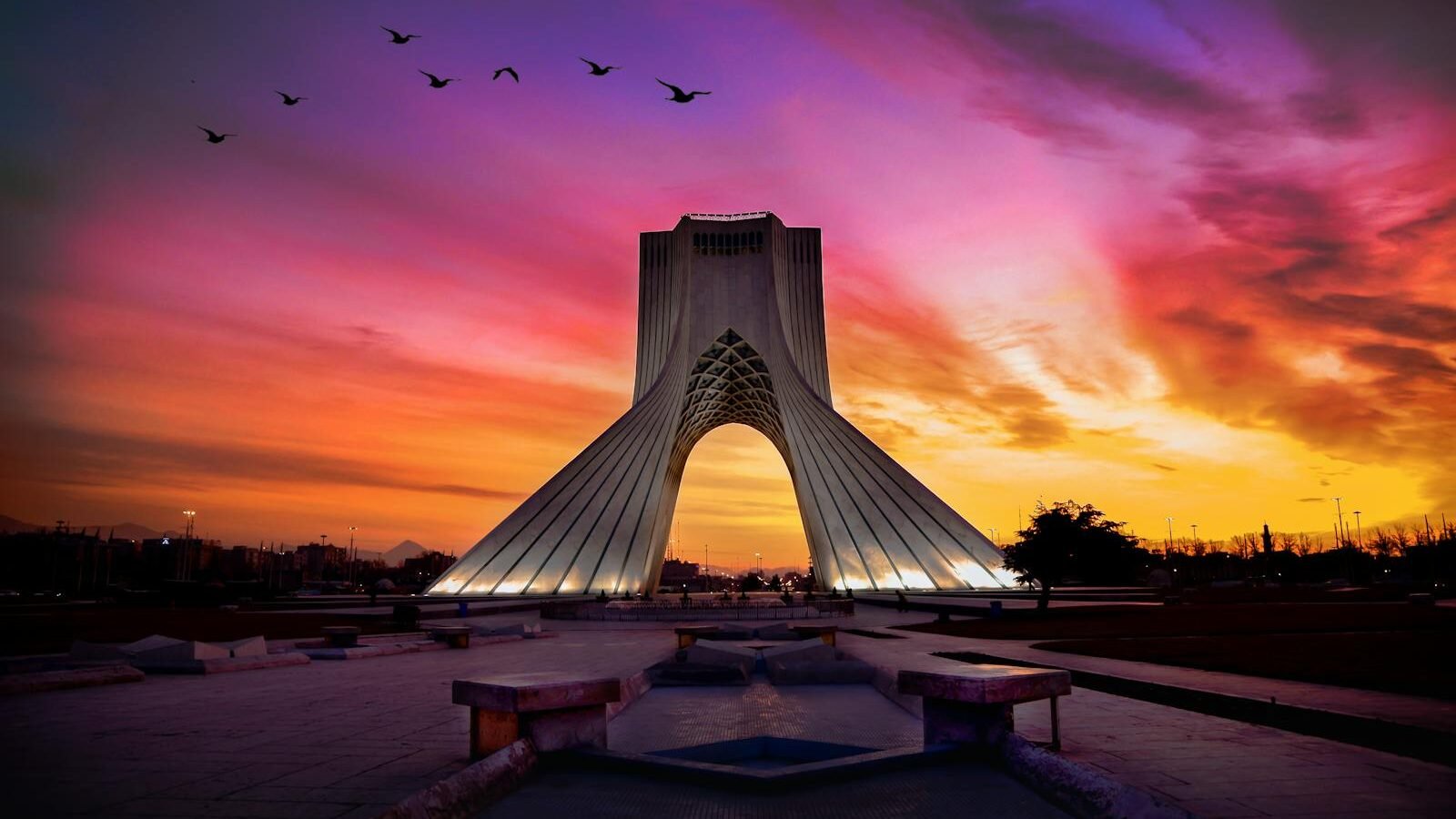 Birds Flying over a Building During Sunset