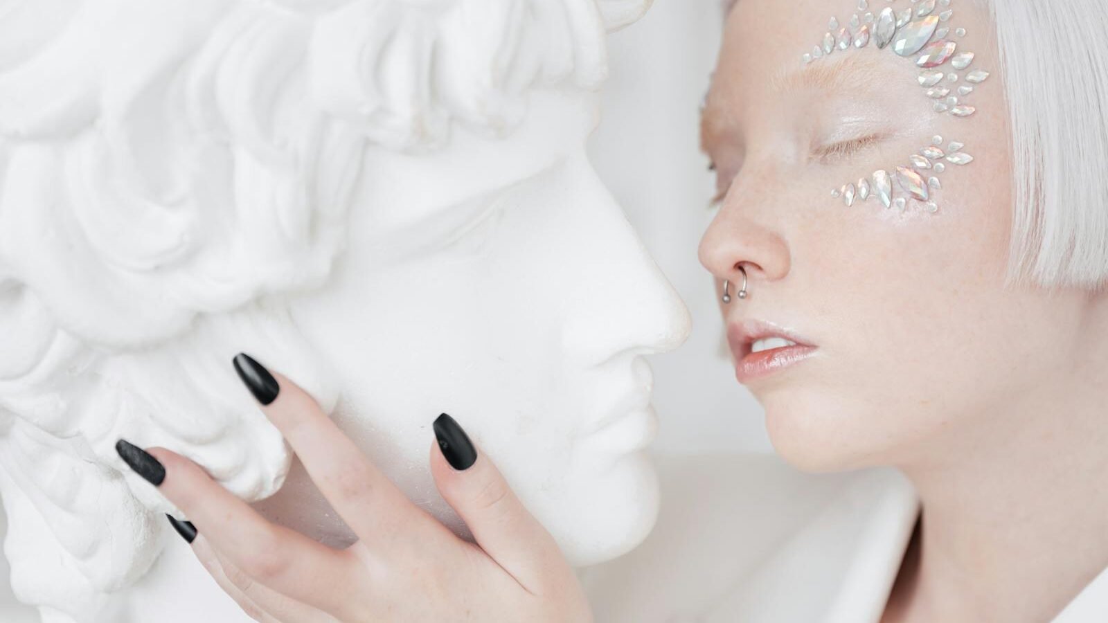 Woman with Face Accessories Touching a Sculptures Face